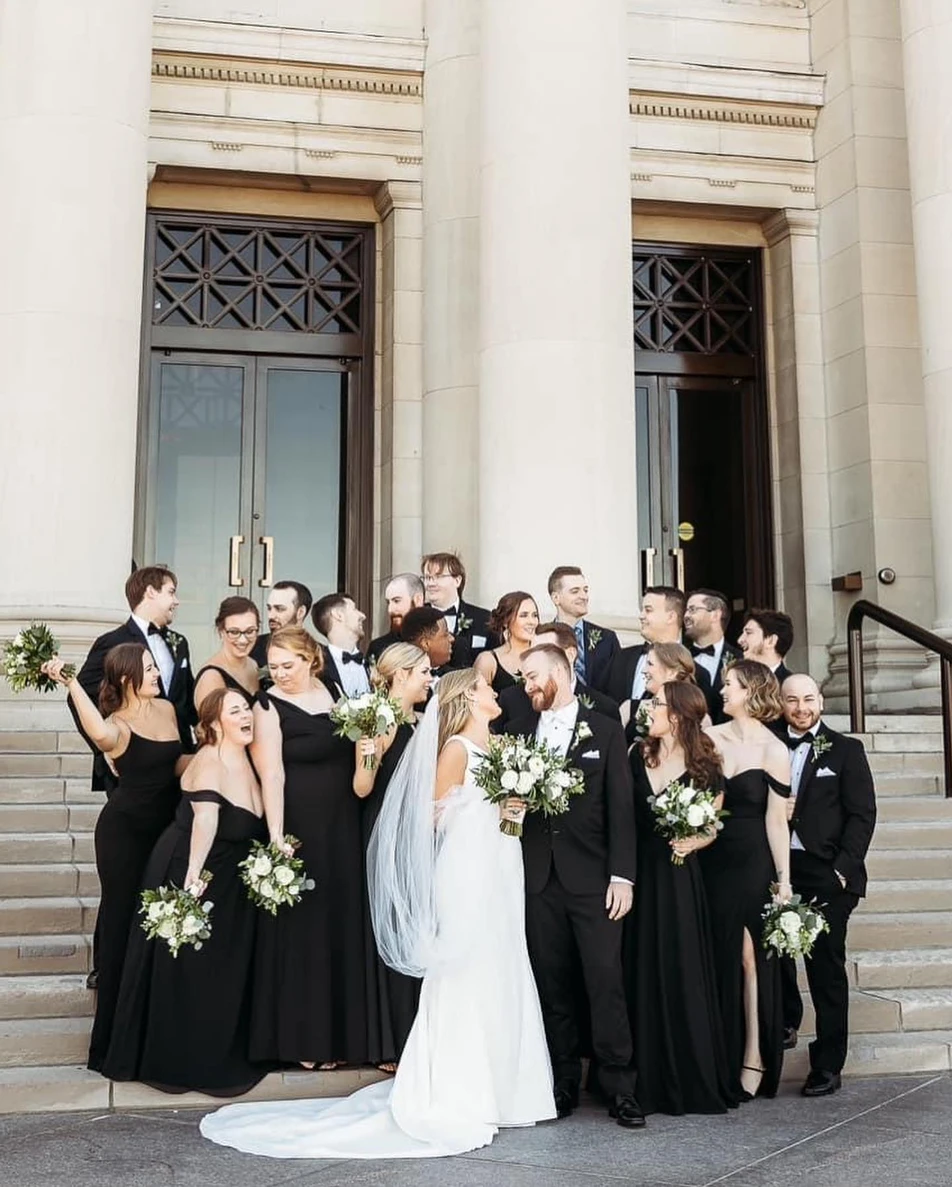 A bride and groom pose together on grand stone steps outside their Alton wedding venue.