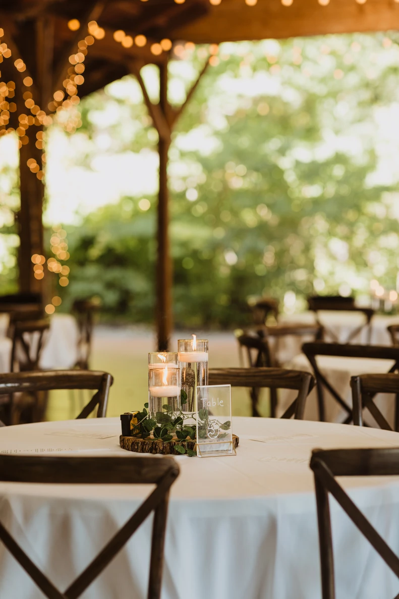 A candlelit reception table dressed with white flowers and taper candles.